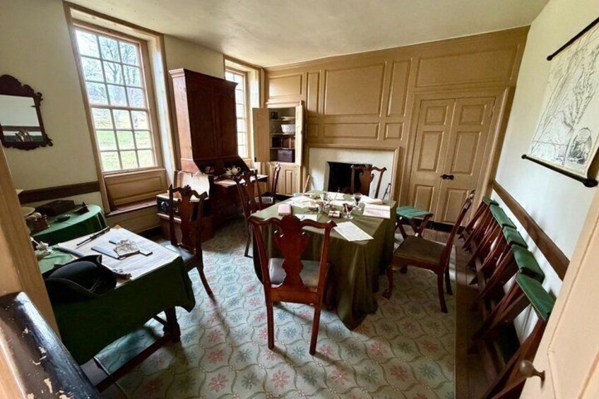 A room with wooden furniture, a fireplace, and a window. 1