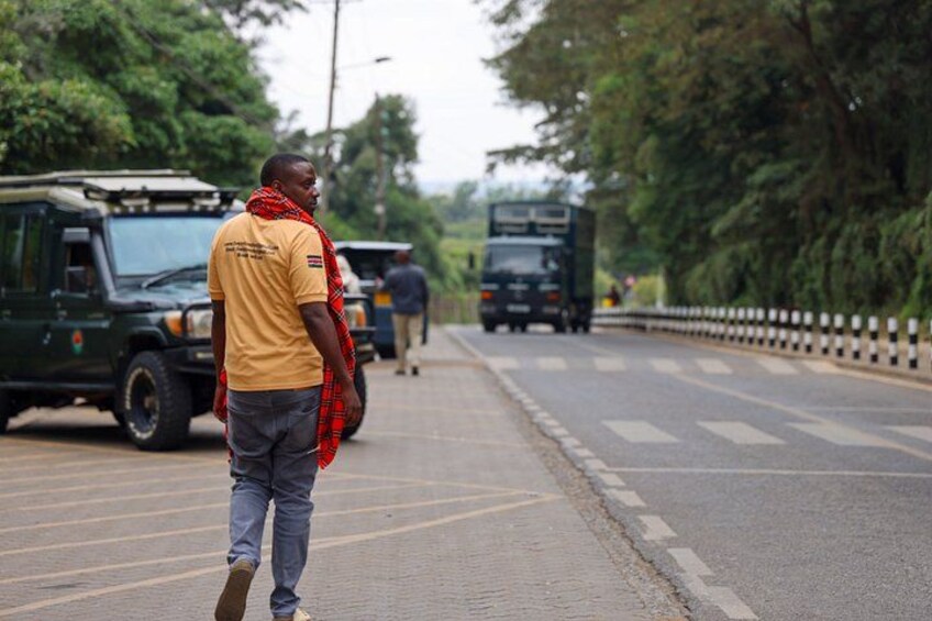 A man walking on a road with vehicles in the background. 4