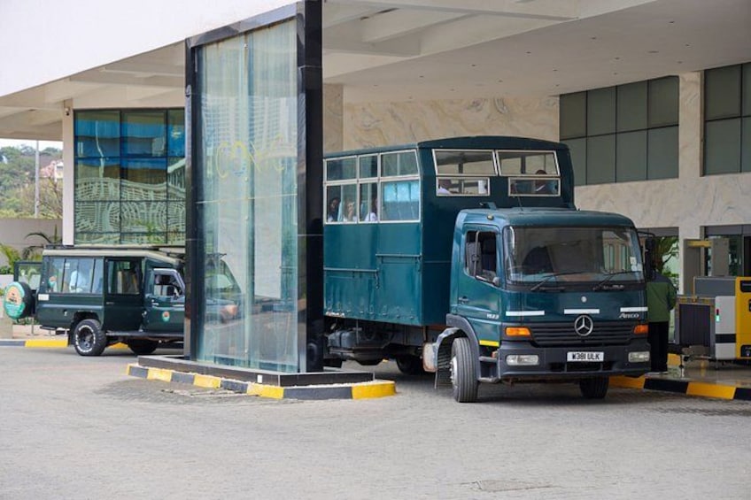 A green truck parked at a gas station with a building in the background. 2
