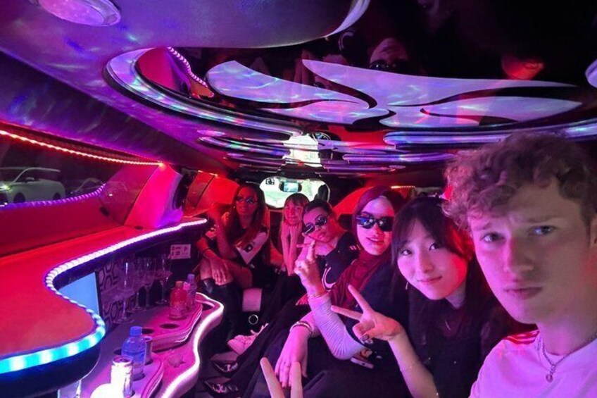 A group of people in a dimly lit, neon-lit interior space with curved ceiling designs. 1