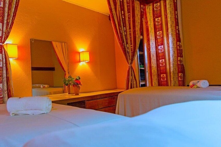 A hotel room with two beds, a mirror, a dresser, and a window with curtains. 2