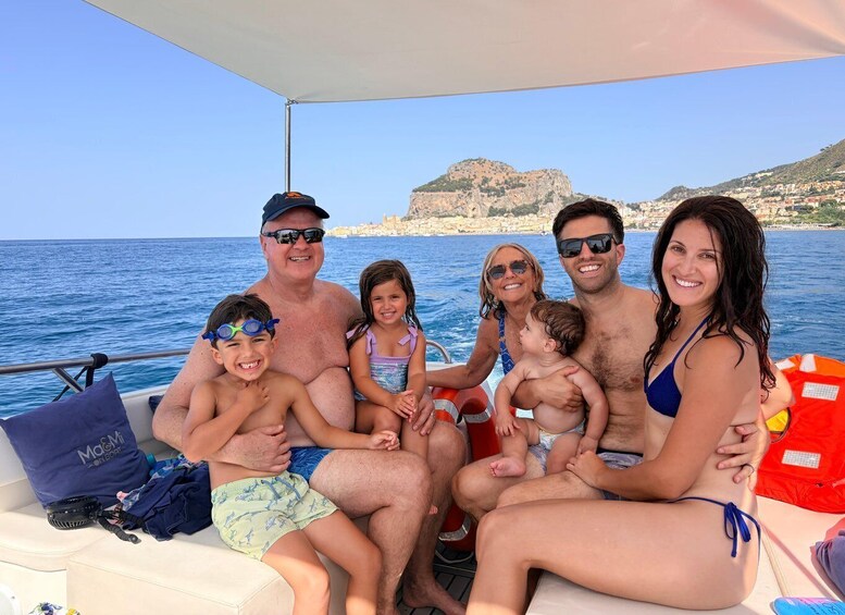 A family on a boat with a coastal landscape in the background. 5