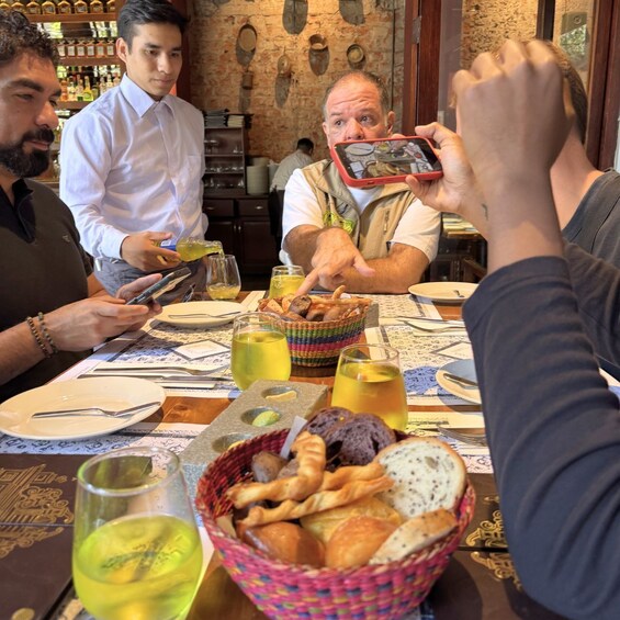 A group of people dining at a restaurant with a rustic brick wall and wooden shelves in the background. 5