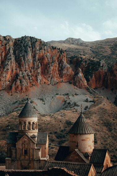 A church with a bell tower and a smaller building in a rocky, hilly landscape. 4