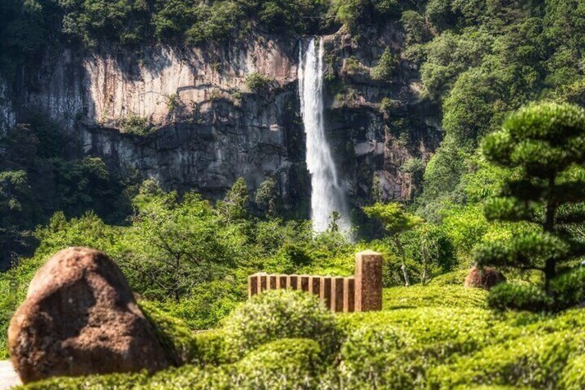A waterfall, lush greenery, and a traditional stone structure. 5