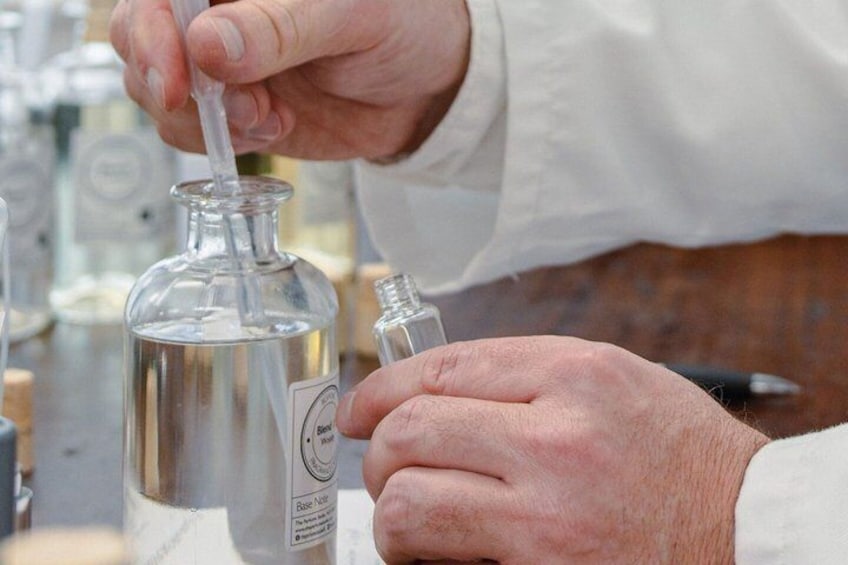A person using a dropper to extract a liquid from a glass bottle. 4
