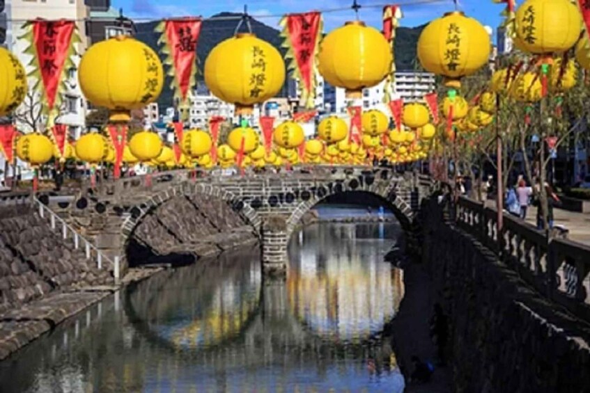 A bridge over a river with yellow lanterns and red banners. 5