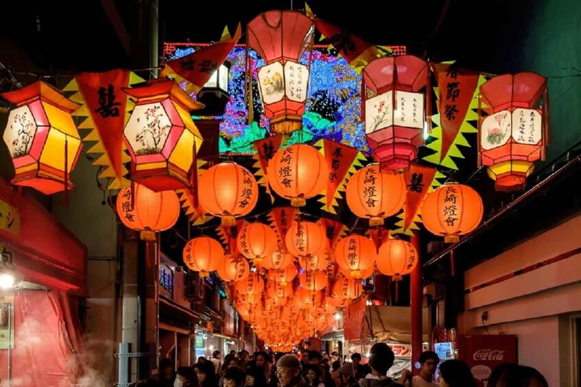 A street decorated with numerous traditional lanterns and colorful lights. 1