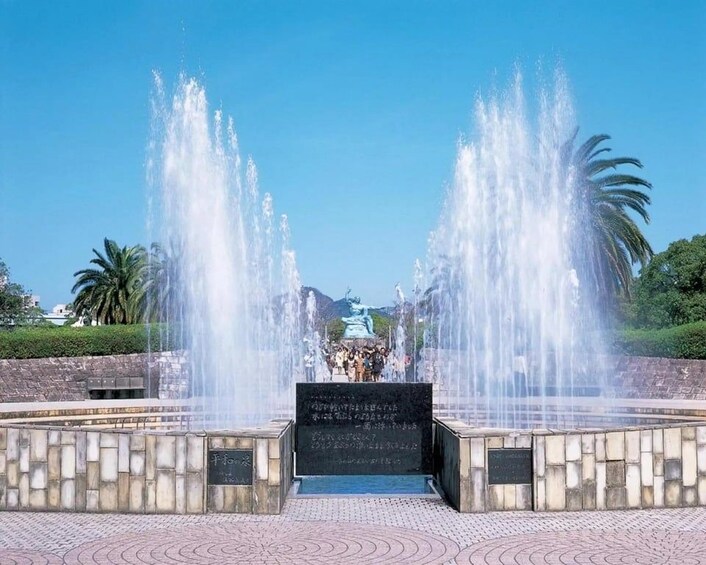 A fountain with water jets, a central statue, and a plaque with inscriptions. 5