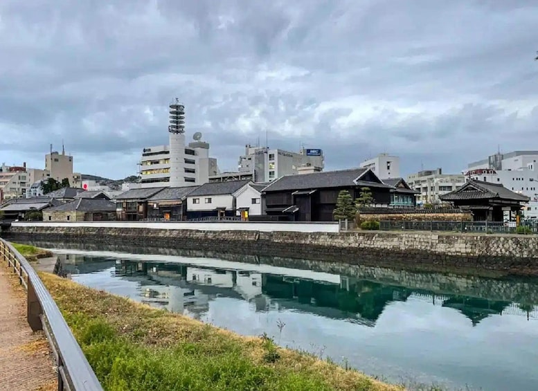 A calm river with traditional Japanese buildings and a modern tower in the background. 2