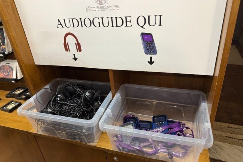 A display with headphones and a mobile phone, labeled 'AUDIOGUIDE QUI'. 5