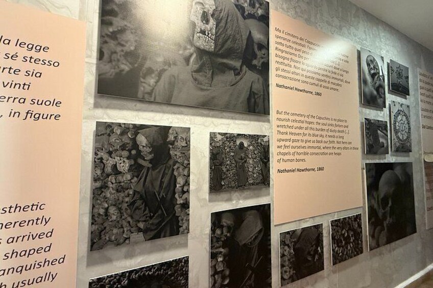 A wall with multiple black and white photographs and text panels. 4