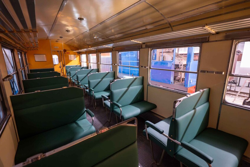 A train interior with green seats and windows. 2