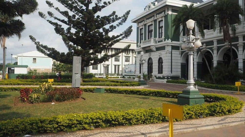 A formal building with columns and a statue in a landscaped garden. 2