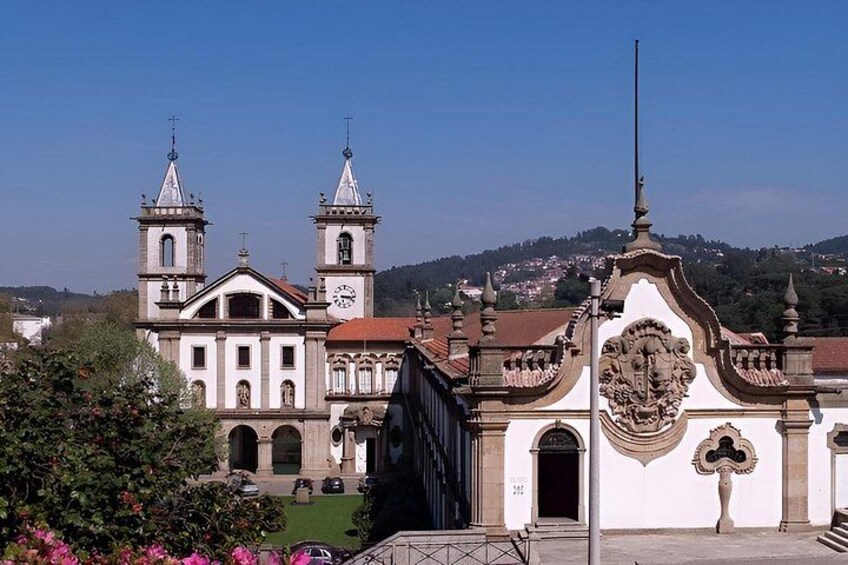 A historic church with two towers, a clock, and a decorative facade. 1