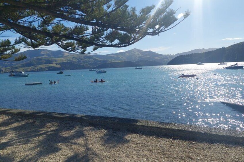 A calm lake with boats, a clear sky, and mountains in the background. 5