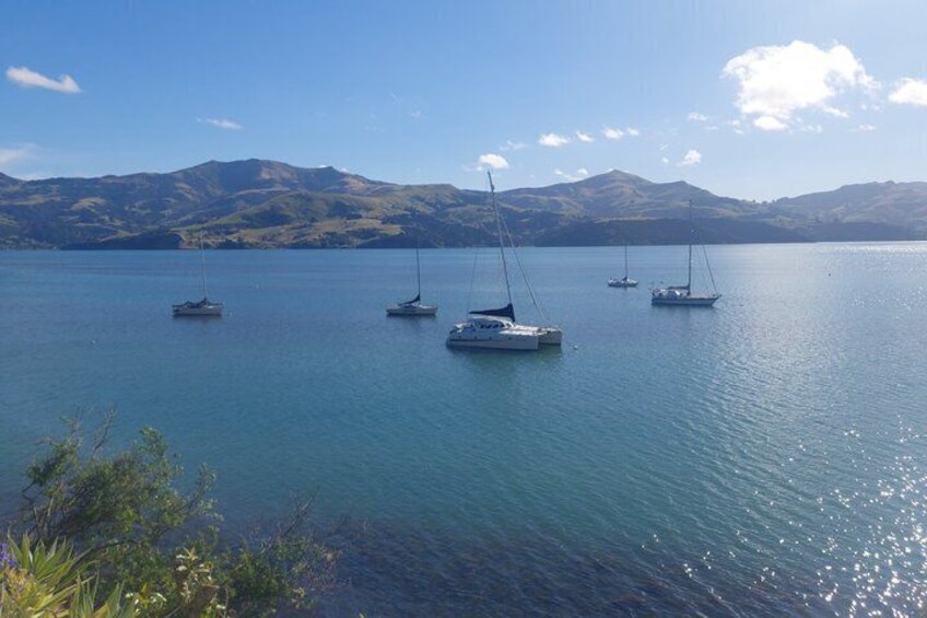 A calm lake with sailboats anchored, surrounded by hills. 4