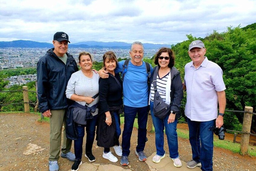 Un grupo de personas de pie en un sendero, con un paisaje urbano al fondo. 2