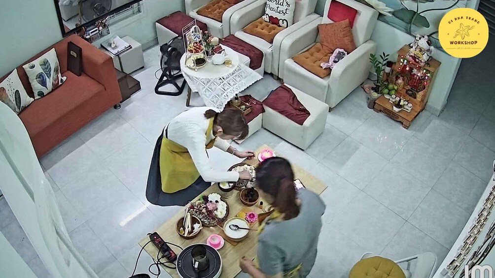 A room with a dining table set for a meal, surrounded by sofas and chairs. 5