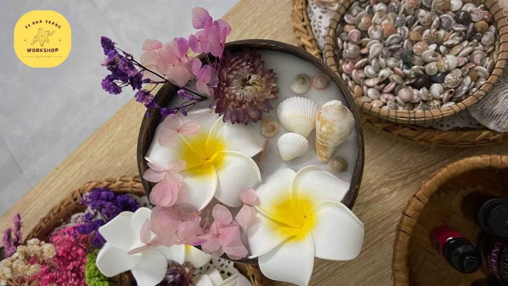 A bowl of flowers and seashells on a wooden surface. 2