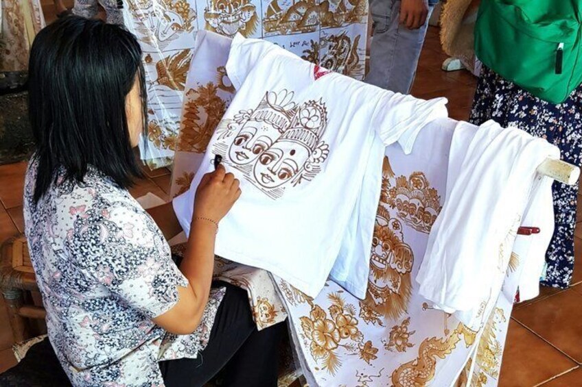 A person drawing on a white t-shirt with a floral pattern. 3