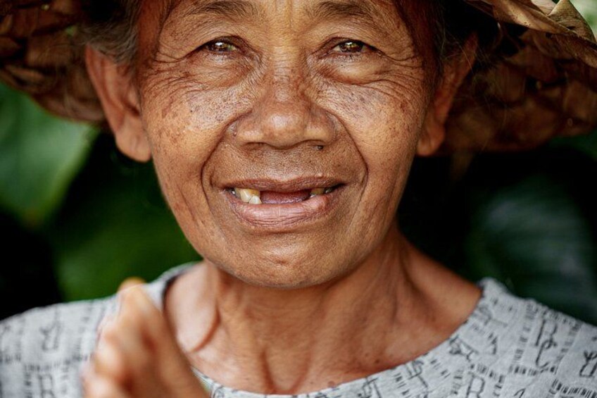 A person wearing a patterned top and a straw hat. 5
