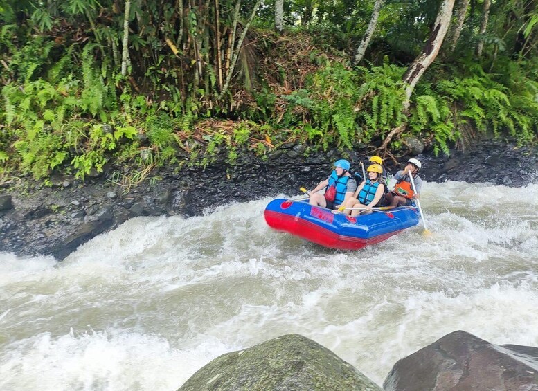 A group of people rafting down a river surrounded by dense greenery. 2