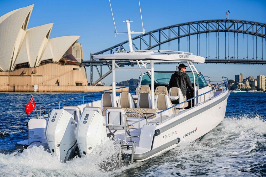 A boat named SPECTRE 2000 moving on water with Sydney Harbour Bridge and Sydney Opera House in the background. 2