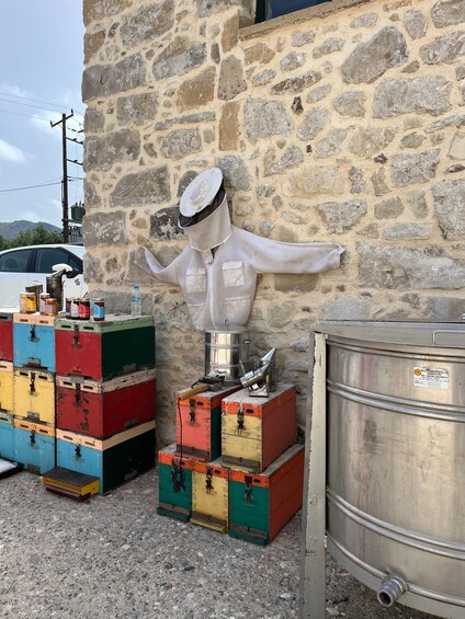 A stone wall with a metal tank and colorful crates stacked against it. 3