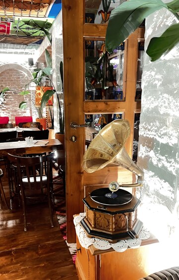 Une platine vinyle en bois posée sur une table, un coin repas avec des chaises et un mur en briques. 3