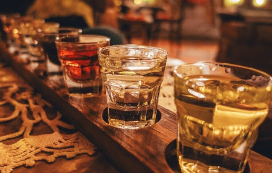 Un plateau en bois sur lequel se trouvent plusieurs verres contenant différentes boissons. 1