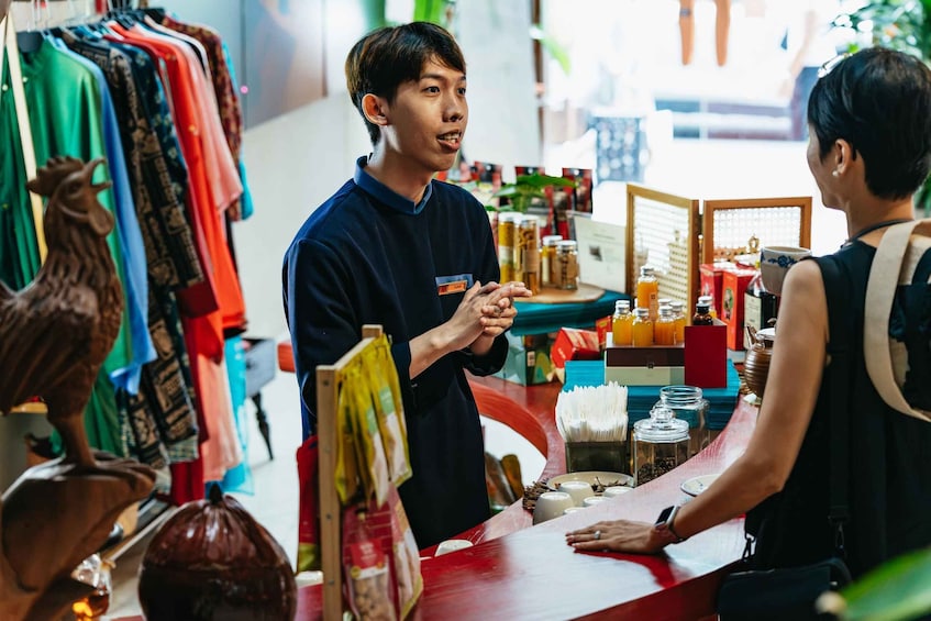 A person at a counter in a store with various items like jars and bags. 3