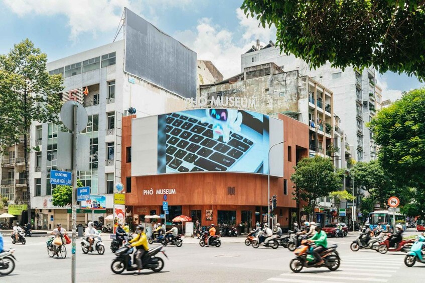 A busy street with a large building featuring a prominent keyboard advertisement. 1
