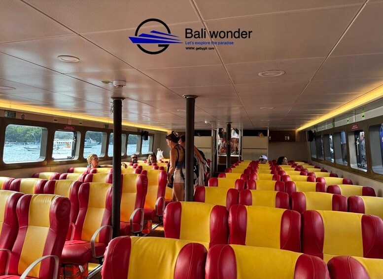 A ferry interior with rows of yellow and red seats, passengers, and a view of the water outside. 4