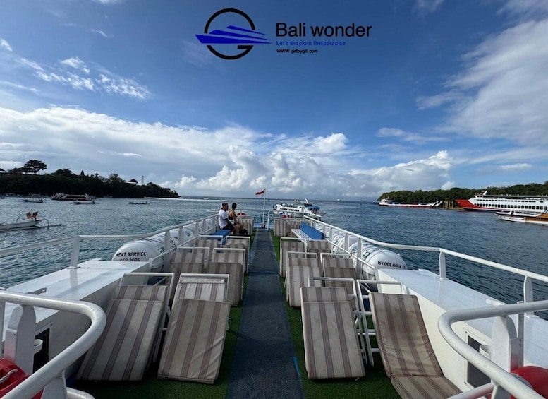 A ferry deck with rows of sun loungers, a couple sitting, and a clear view of the water and distant land. 5