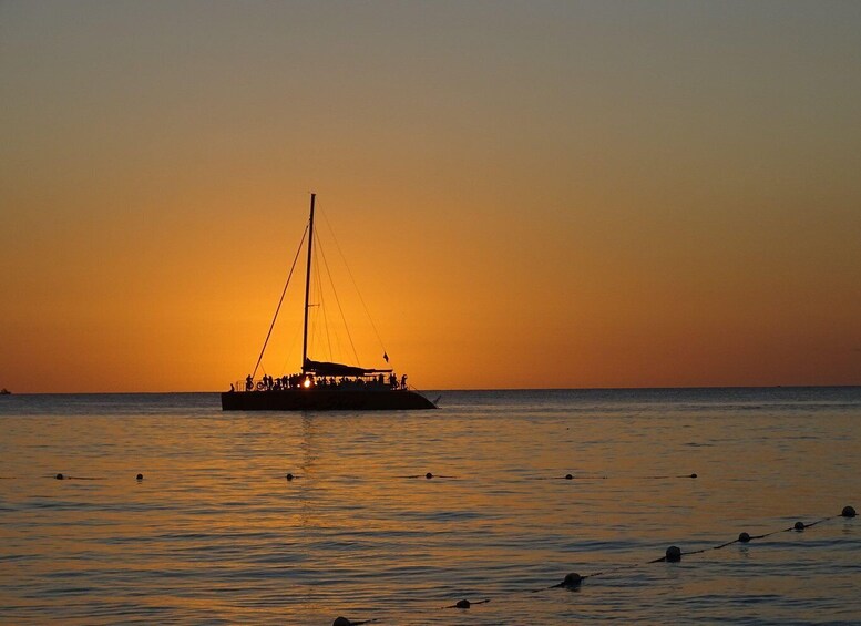 A sailboat with people on board at sunset. 5