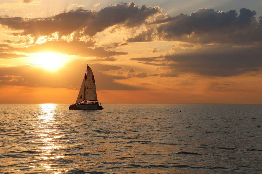 A sailboat on the ocean during sunset. 1