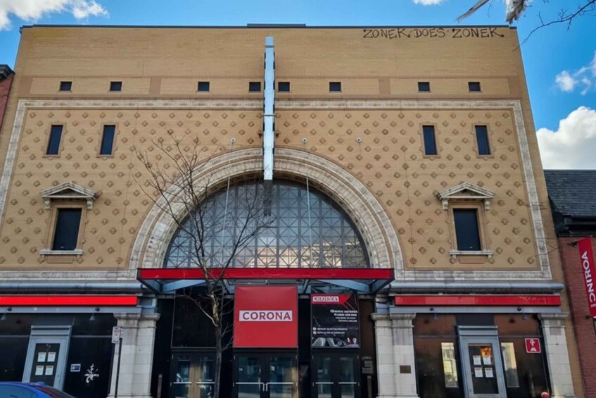 A building with a large arched entrance and a 'CORONA' sign. 2