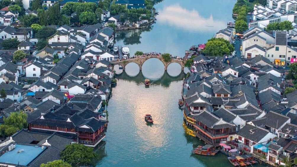A riverside town with traditional architecture, a bridge, and boats. 1
