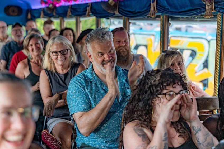 A group of people on a bus, some with visible tattoos, and a blue patterned shirt. 3