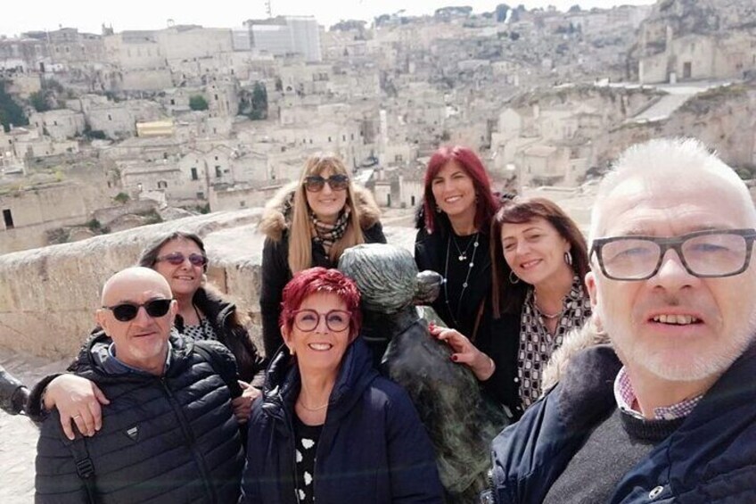 A group of people on a rooftop overlooking a historic cityscape with ancient buildings. 5