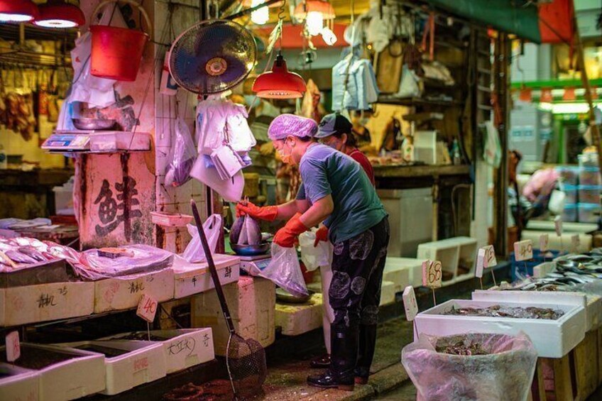 A market stall with various items for sale, including fish and other goods. 5