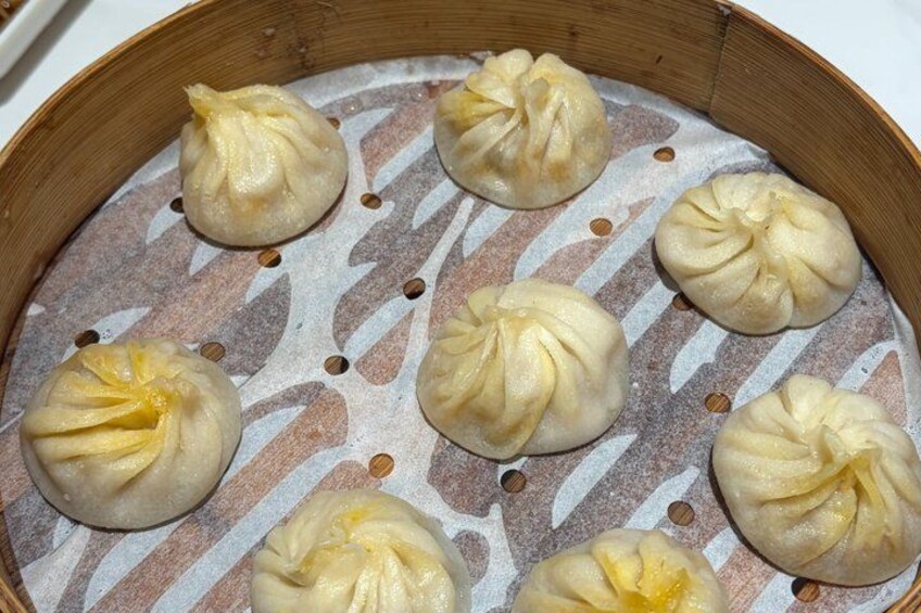 Una cuocivapore in bambù con sei baozi (panini al vapore cinesi) disposti a cerchio. 4
