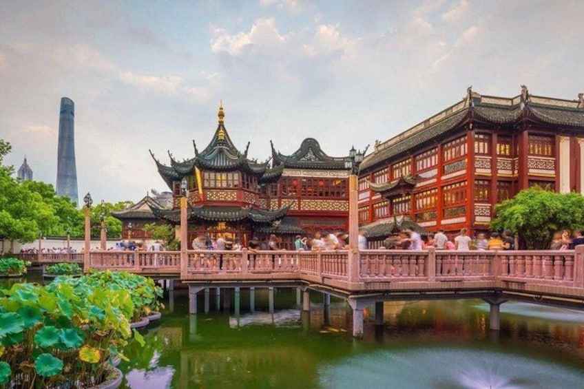 Un padiglione cinese tradizionale con architettura elaborata, un ponte e uno specchio d'acqua che riflette la struttura. 3