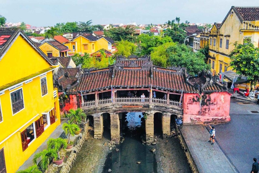 A traditional bridge over a canal, surrounded by colorful buildings and lush greenery. 5