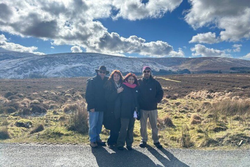 A group of people standing on a road with a mountainous landscape in the background. 2