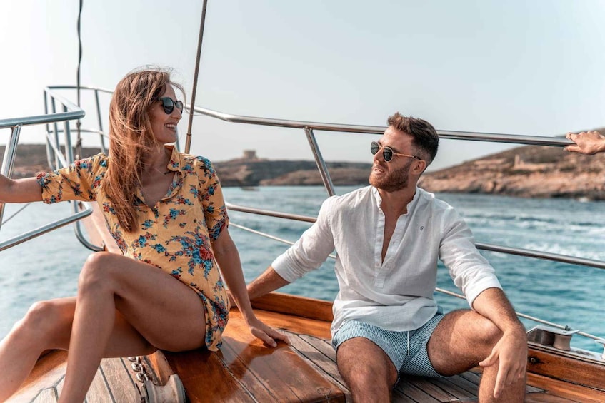 Two people on a wooden boat with metal railings, sitting by the water. 1