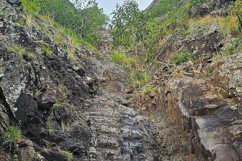 A rocky terrain with a narrow path leading through a canyon. 4