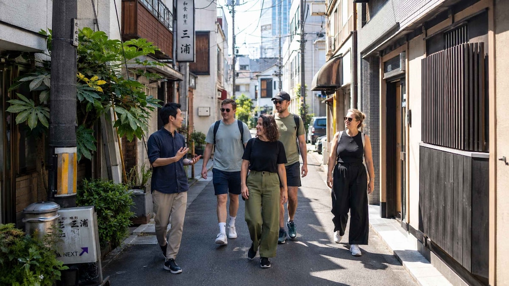 A narrow urban street with pedestrians walking. 4