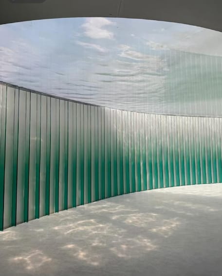 A curved glass structure with vertical panels. 4